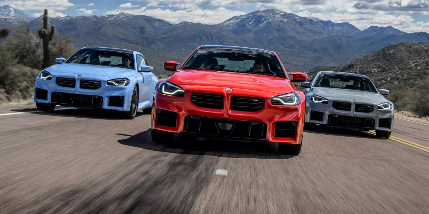 Frontal view of three 2024 BMW M2 coupes driving on a highway