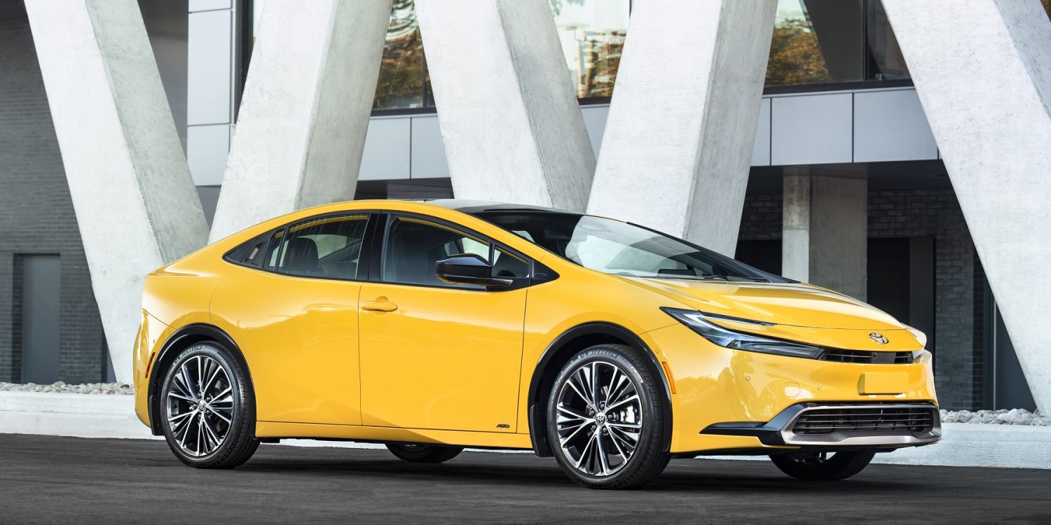 Three-quater side view of a 2024 yellow Toyota Prius on a city street