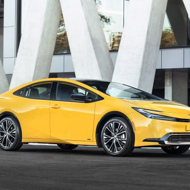 Three-quater side view of a 2024 yellow Toyota Prius on a city street