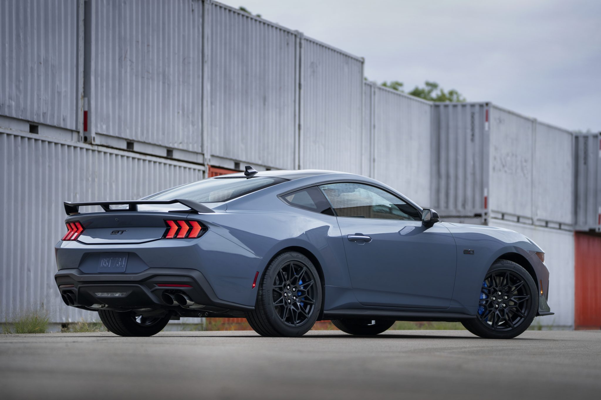 Three-quarter side view of a 2024 blue Ford Mustang