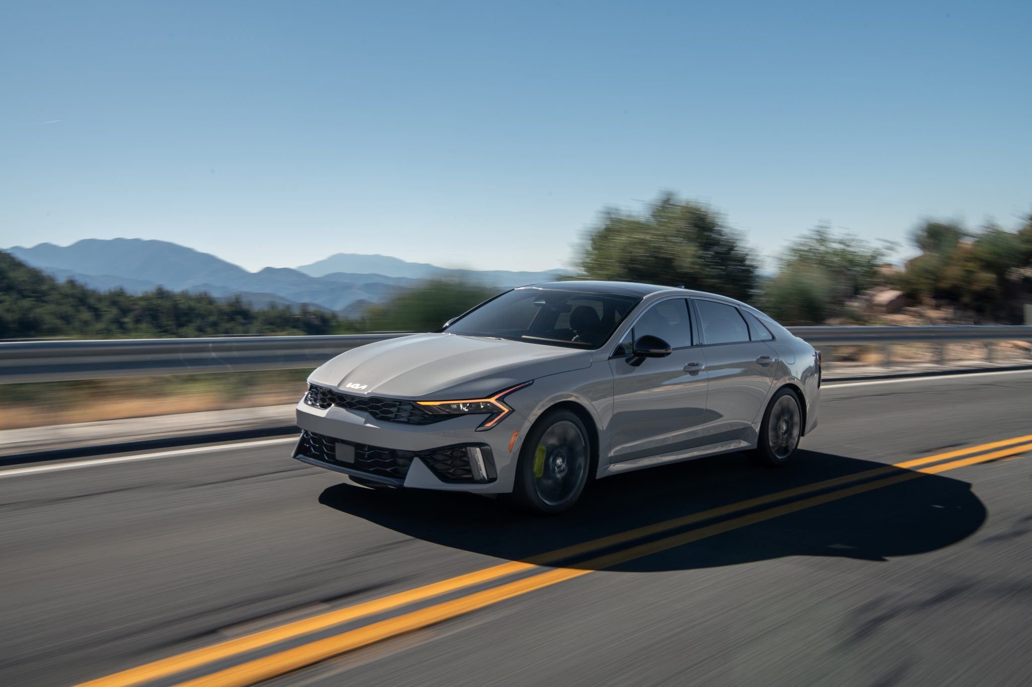 3/4 side view of a 2024 grey Kia K5 cruising